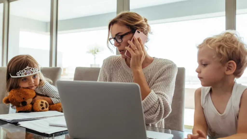 Woman remote working with 2 kids to look after